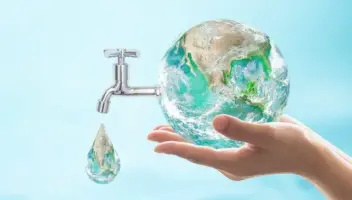 hand holding the world showing a nozzle of water