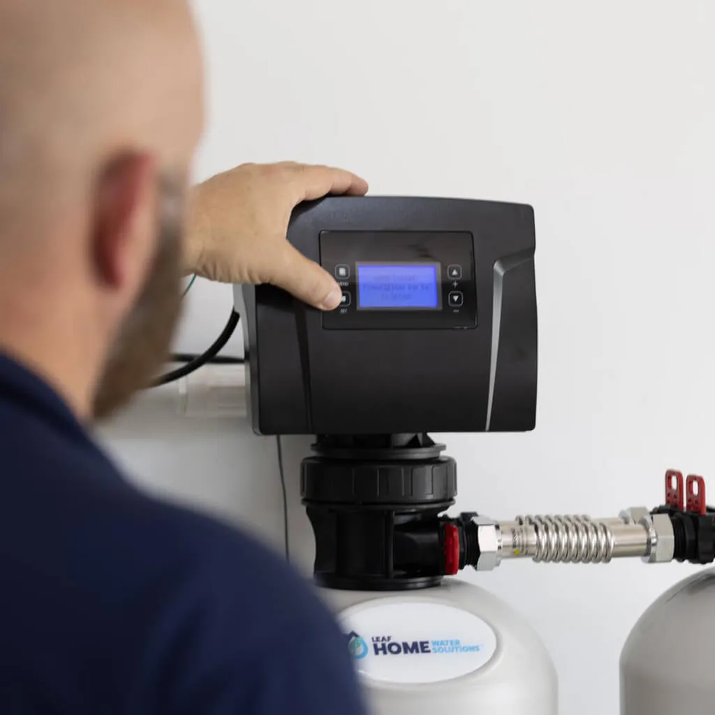 installation expert setting up the digital panel of a water softener system