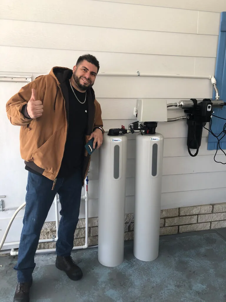 customer smiling alongside their new installation of a water softener system