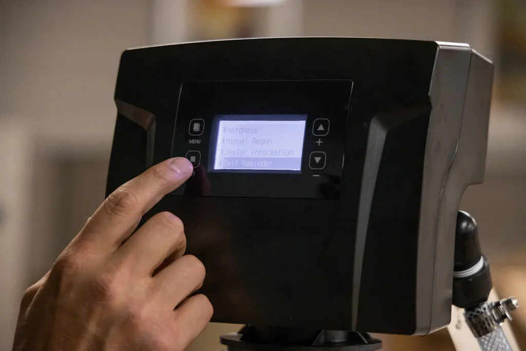 person using a digital screen to setup the in-home water filtration system