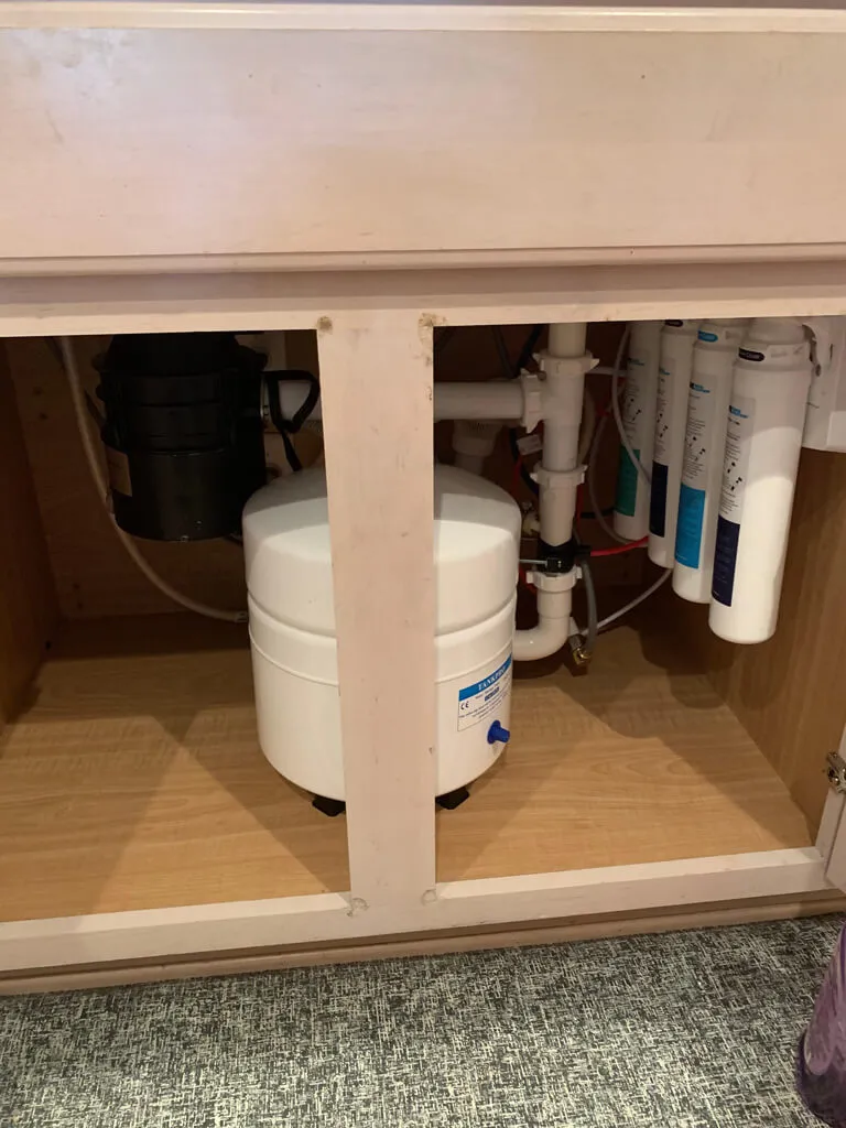 reverse osmosis water filtration system installed beneath kitchen sink