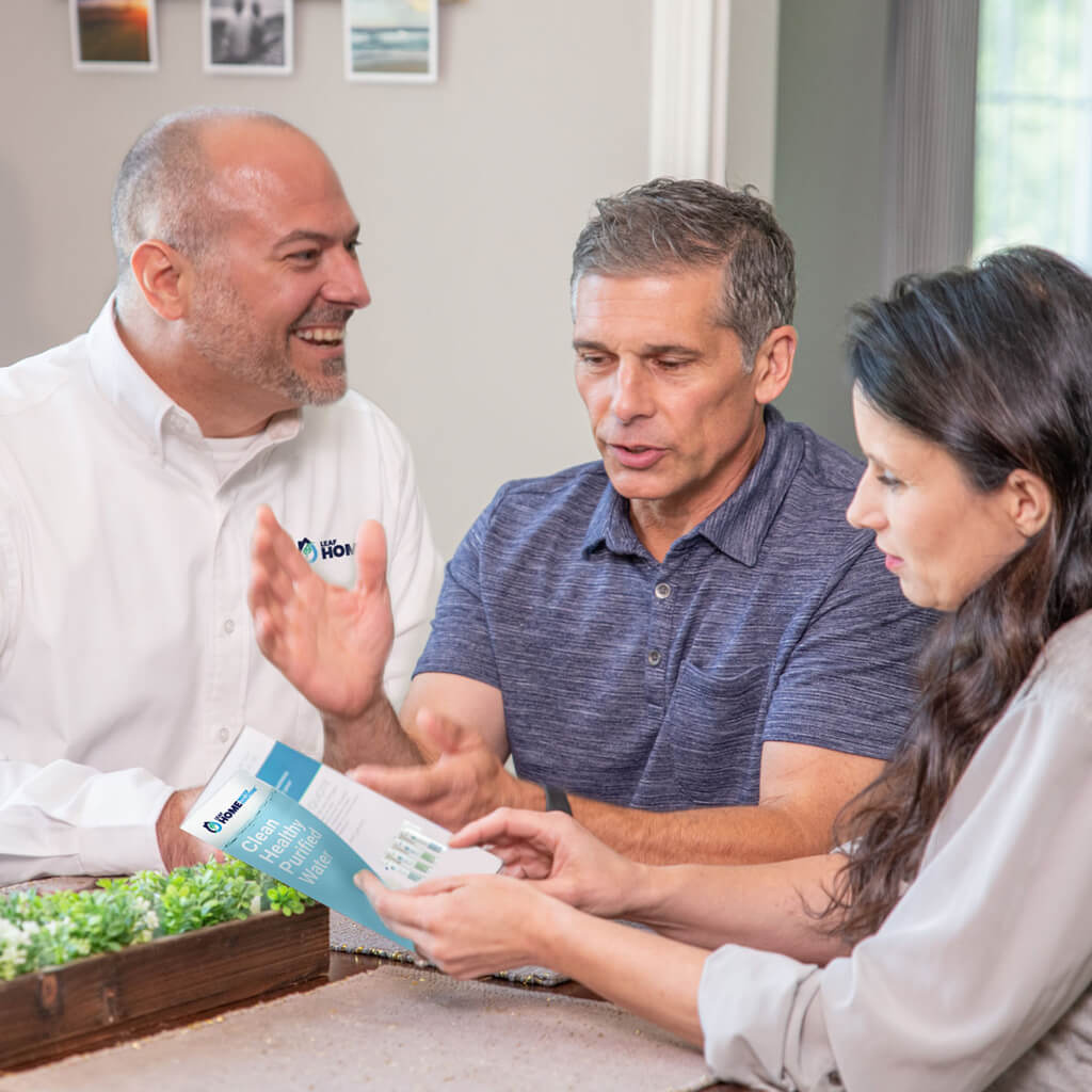 sales team member discussing water solution options with husband and wife