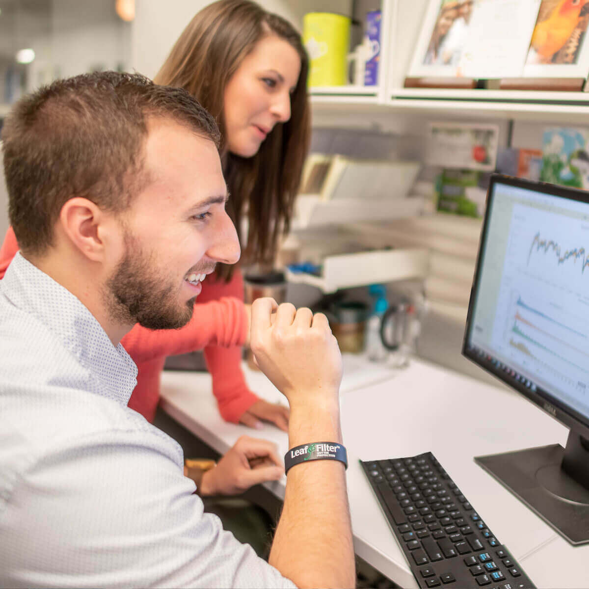employees looking at analytical chart lines on a computer in the office